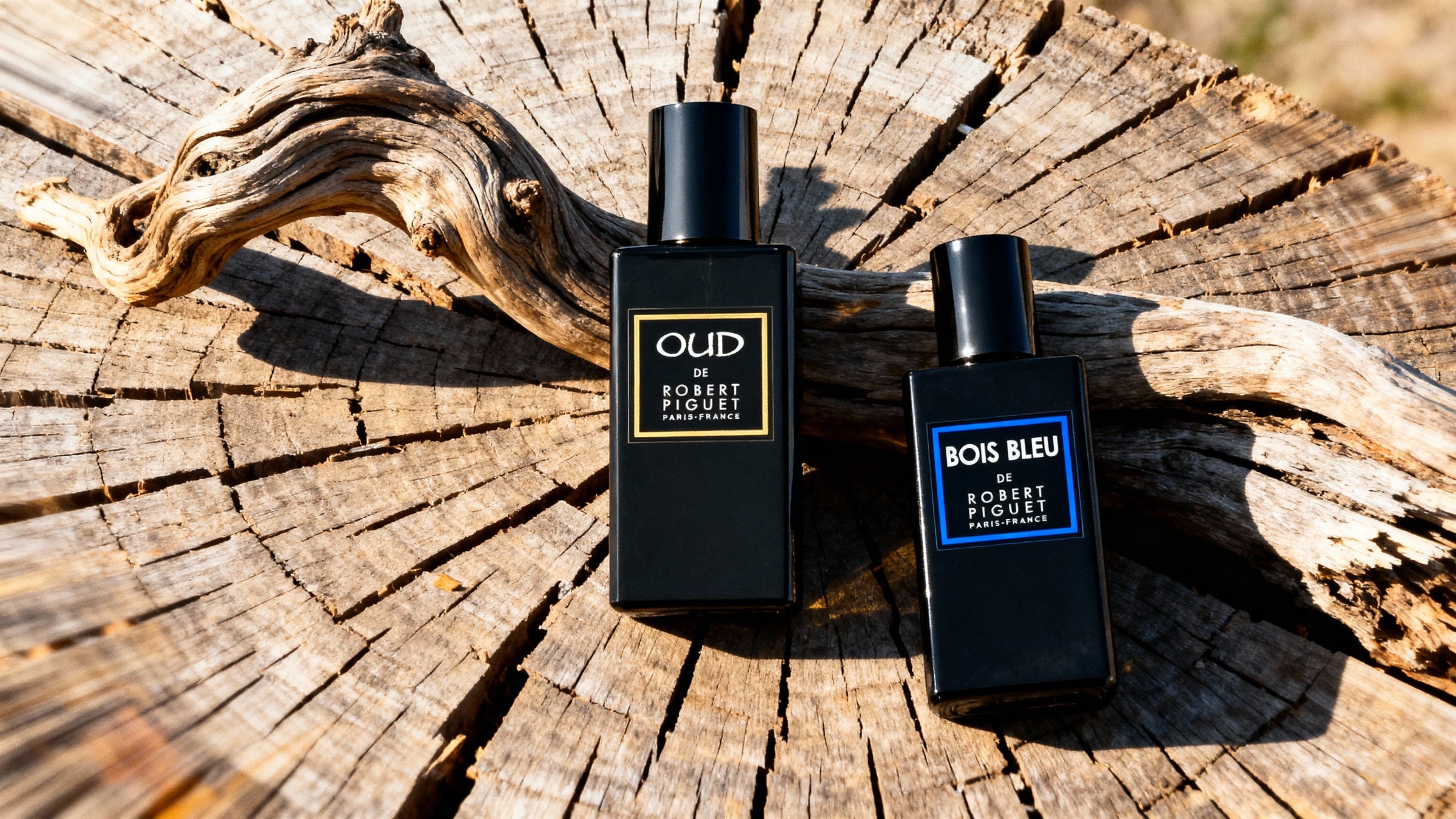 OUD and Bois Bleu bottles on a wooden background